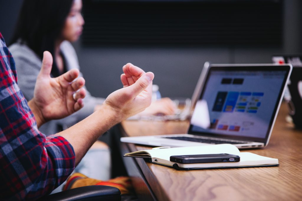 man with flannel shirt giving a great pitch during meeting