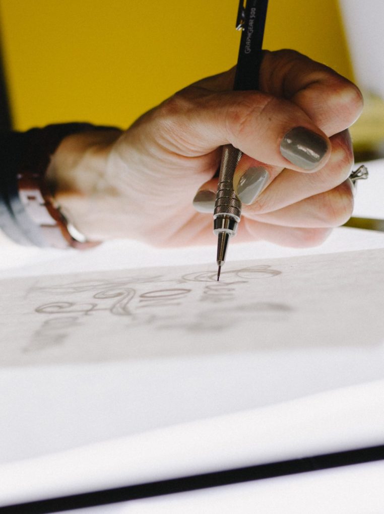 white woman using top design psychology tips with pen on paper
