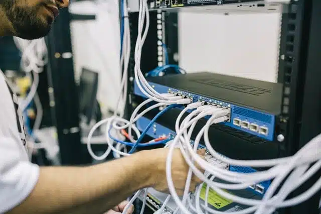 A man plugging cables into a modem